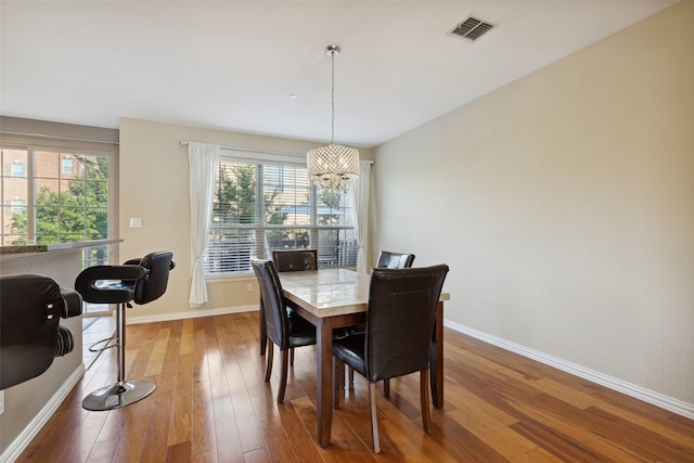 dining area with hardwood / wood-style floors and a chandelier