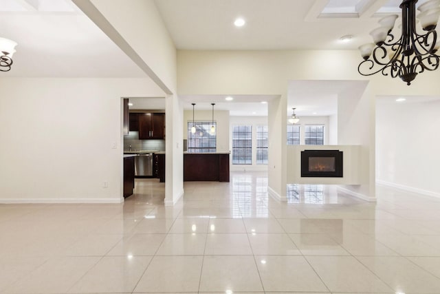 unfurnished living room featuring an inviting chandelier and light tile patterned floors