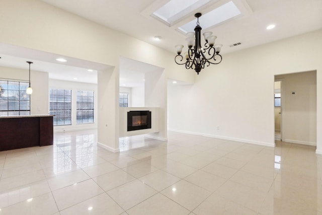 unfurnished living room with a wealth of natural light, light tile patterned floors, and a notable chandelier