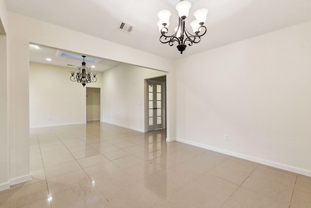 unfurnished room with a notable chandelier