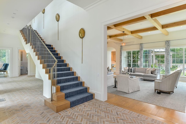 living room featuring light hardwood / wood-style flooring, coffered ceiling, and beamed ceiling