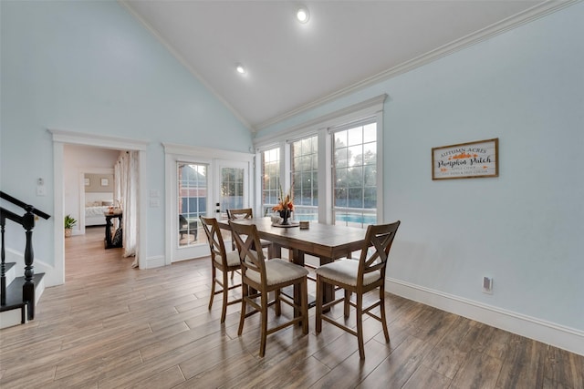 dining space with ornamental molding, light wood-type flooring, french doors, and plenty of natural light