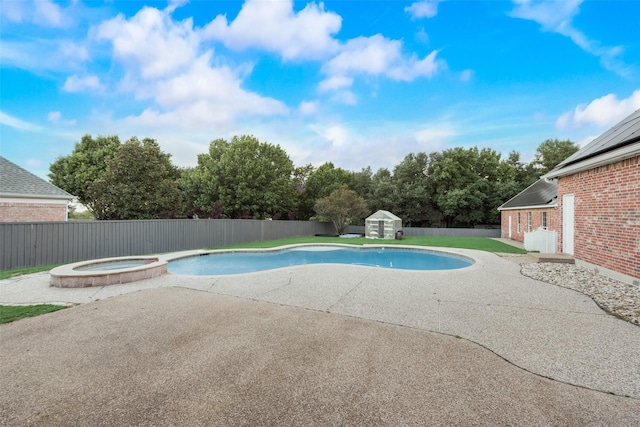 view of swimming pool with a storage unit, a patio area, and an in ground hot tub