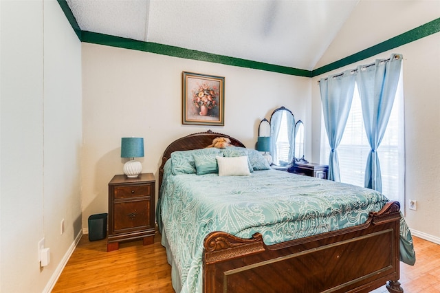 bedroom with lofted ceiling and hardwood / wood-style flooring