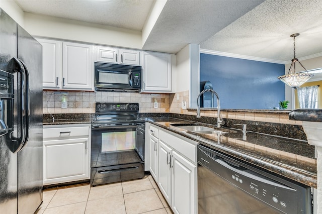 kitchen with sink, white cabinets, light tile patterned floors, dark stone counters, and black appliances