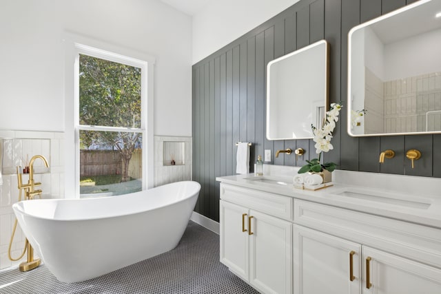 bathroom with a bath, tile patterned flooring, and vanity