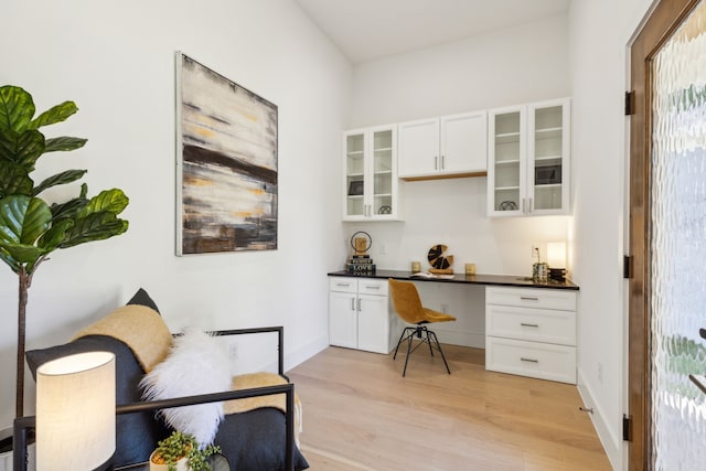 office space featuring built in desk and light hardwood / wood-style flooring