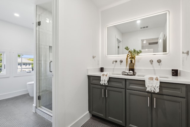 bathroom with toilet, tile patterned flooring, walk in shower, and vanity