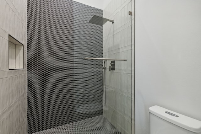 bathroom featuring toilet and tiled shower