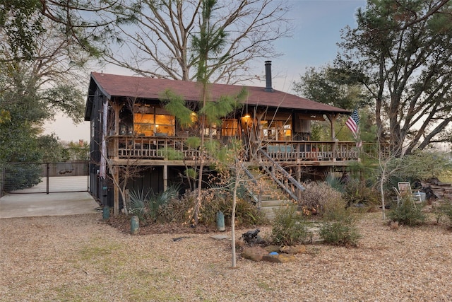 back house at dusk featuring a wooden deck