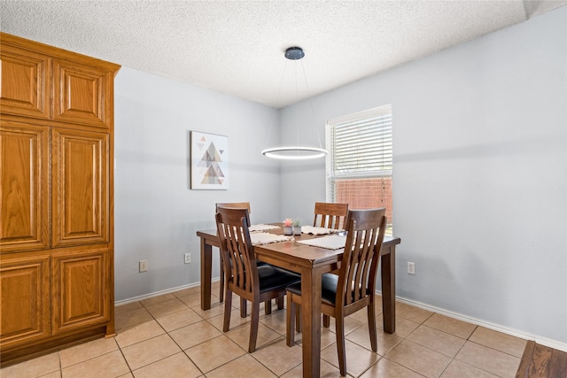 tiled dining area featuring a textured ceiling