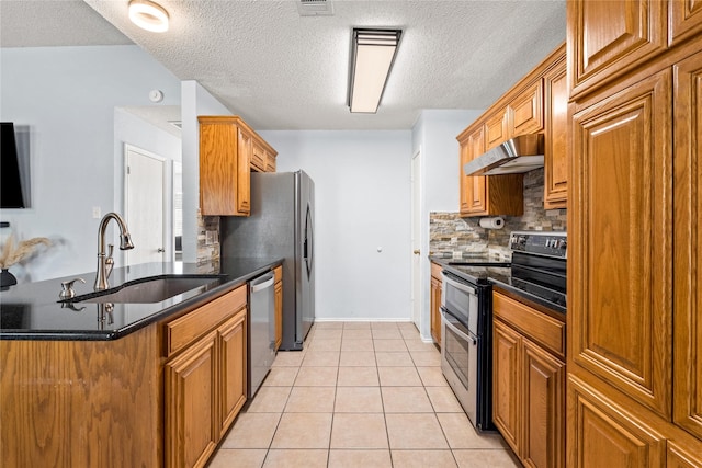 kitchen with appliances with stainless steel finishes, a textured ceiling, sink, and light tile patterned floors