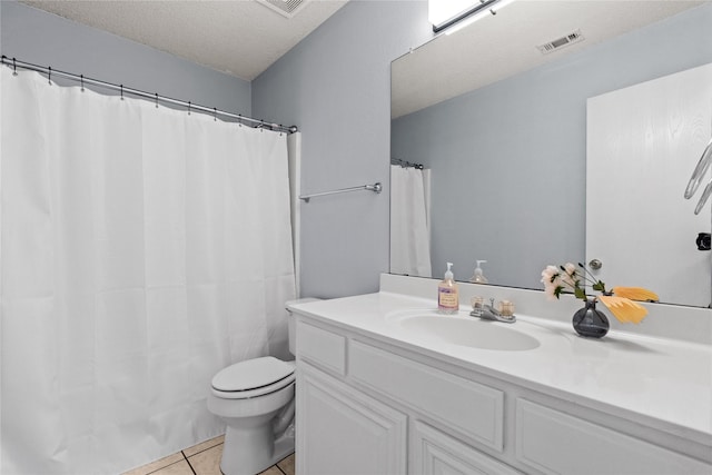 bathroom featuring toilet, vanity, tile patterned floors, and a textured ceiling