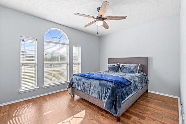 bedroom featuring a textured ceiling, ceiling fan, and hardwood / wood-style flooring