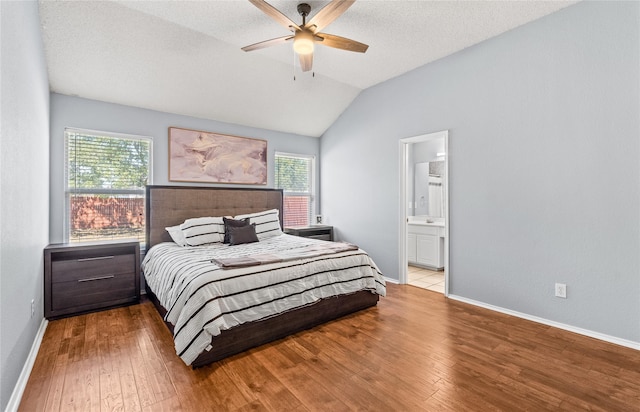 bedroom featuring ceiling fan, a textured ceiling, light hardwood / wood-style flooring, ensuite bathroom, and lofted ceiling