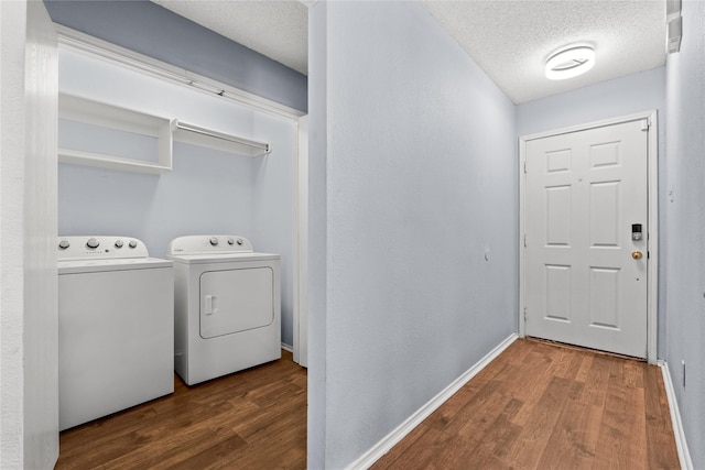 laundry area featuring wood-type flooring, washing machine and clothes dryer, and a textured ceiling