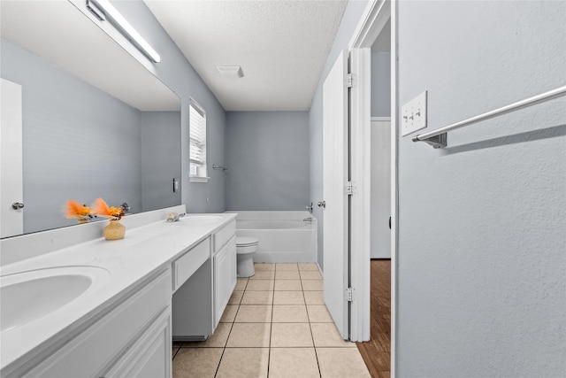 bathroom featuring a textured ceiling, tile patterned flooring, toilet, a washtub, and vanity