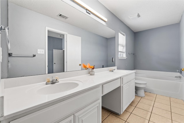 bathroom featuring toilet, a textured ceiling, a tub to relax in, tile patterned floors, and vanity