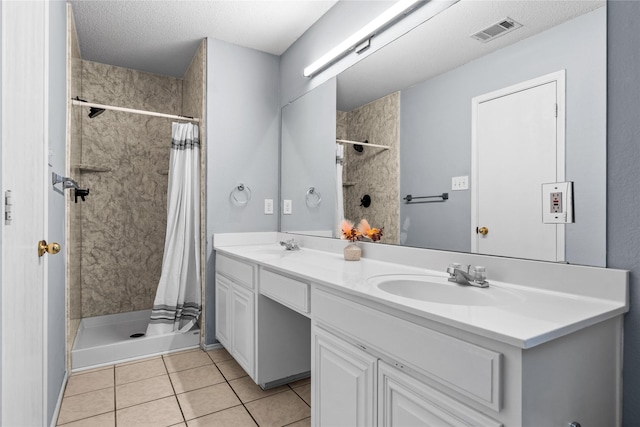 bathroom featuring a textured ceiling, tile patterned floors, walk in shower, and vanity