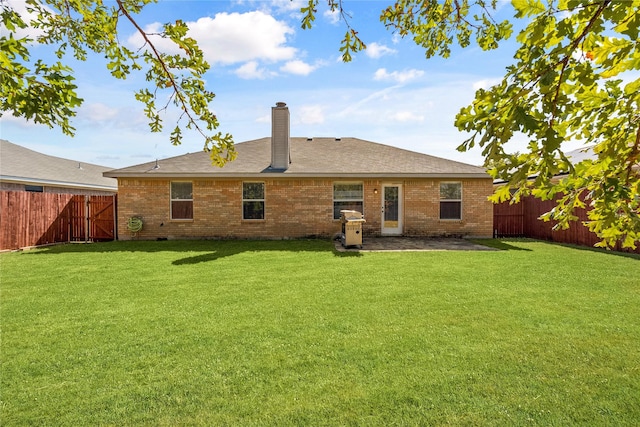 back of property with a yard and a patio