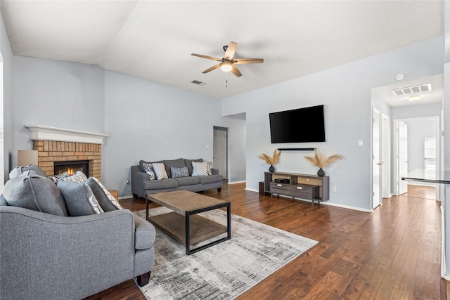 living room with vaulted ceiling, a brick fireplace, ceiling fan, and dark hardwood / wood-style flooring