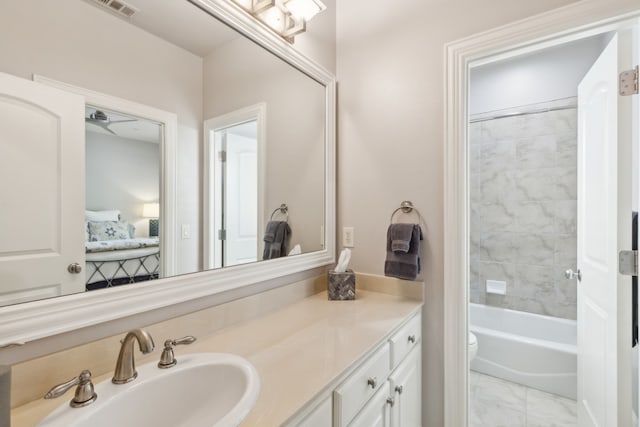 full bathroom featuring toilet, tiled shower / bath combo, vanity, and ceiling fan