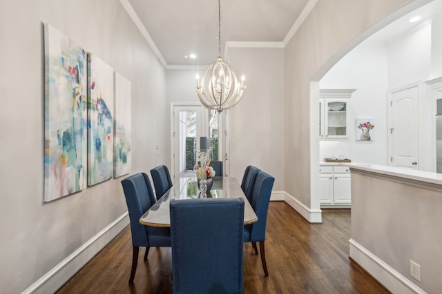 dining room with an inviting chandelier, ornamental molding, and dark hardwood / wood-style flooring