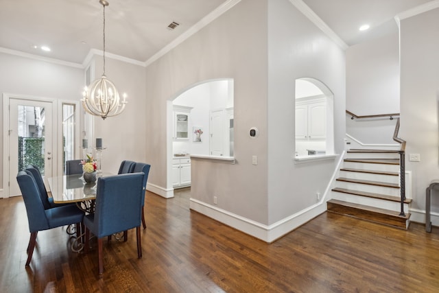 dining room with an inviting chandelier, crown molding, and dark hardwood / wood-style floors