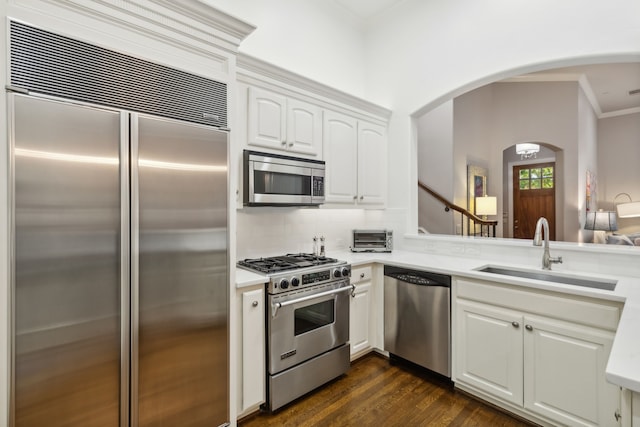 kitchen with stainless steel appliances, sink, white cabinetry, tasteful backsplash, and dark hardwood / wood-style floors