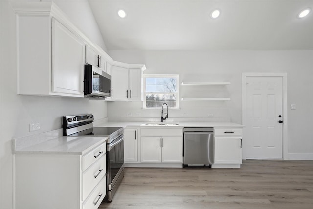 kitchen with open shelves, stainless steel appliances, light countertops, white cabinets, and a sink