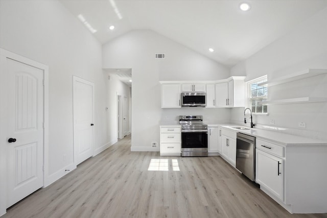 kitchen featuring high vaulted ceiling, sink, white cabinetry, and stainless steel appliances