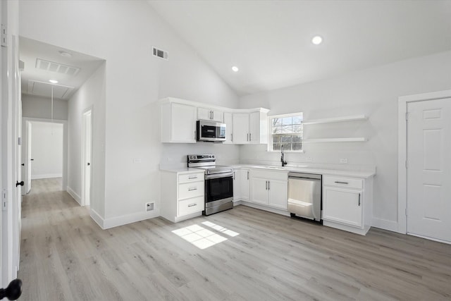 kitchen featuring light hardwood / wood-style floors, stainless steel appliances, high vaulted ceiling, white cabinets, and sink