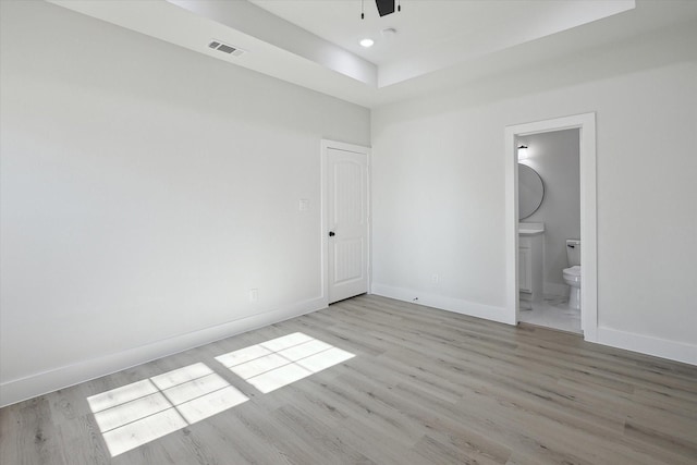 unfurnished bedroom with ceiling fan, light hardwood / wood-style floors, and ensuite bath