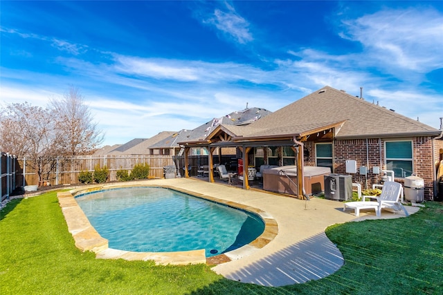 view of pool with a hot tub, a patio area, and a lawn