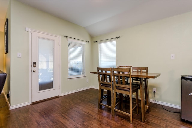 dining room with vaulted ceiling and dark wood-type flooring