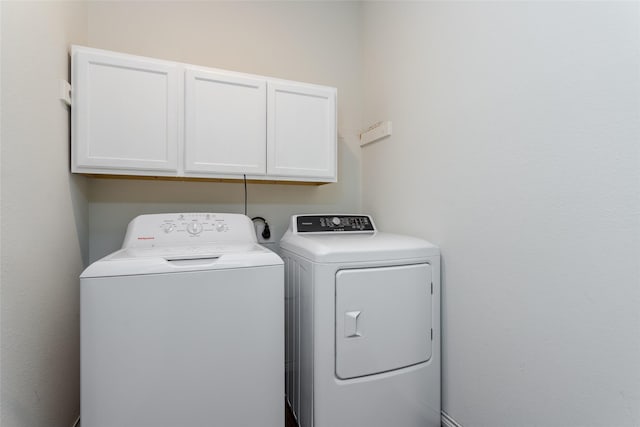 laundry area featuring washer and dryer and cabinets