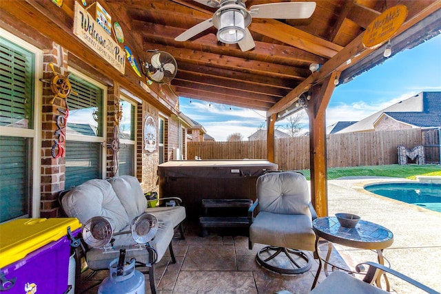 view of patio with ceiling fan and a swimming pool with hot tub