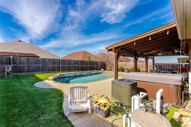 view of pool featuring a lawn, ceiling fan, and a hot tub