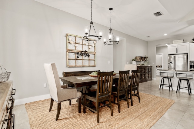 dining room with light tile patterned floors and a chandelier