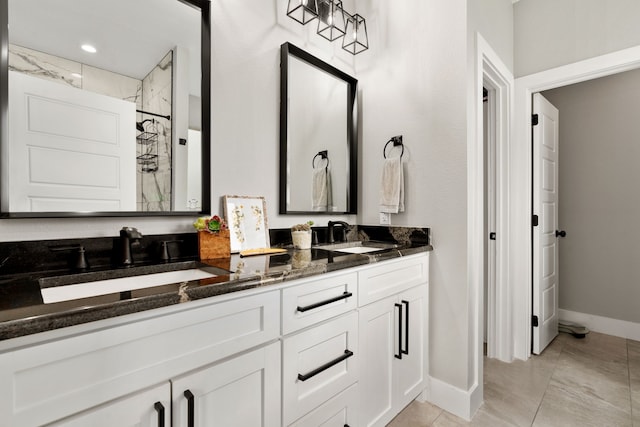 bathroom with vanity, tile patterned flooring, and tiled shower