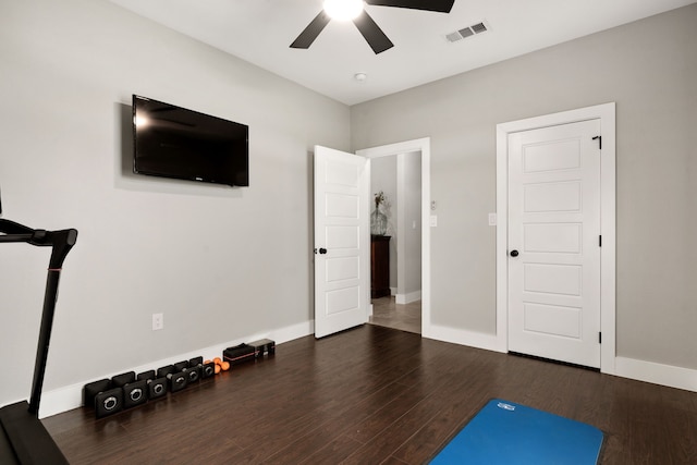 workout area with dark hardwood / wood-style flooring and ceiling fan