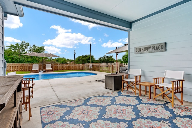 view of pool with a patio, pool water feature, and a fire pit