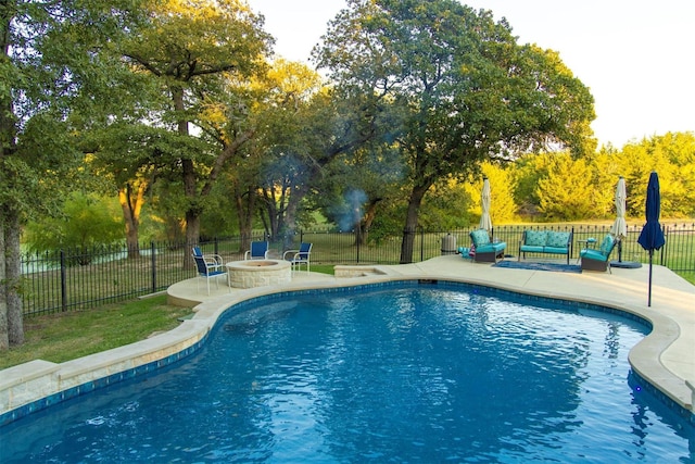 view of swimming pool featuring a fire pit and a patio