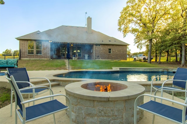 view of pool featuring an outdoor fire pit, a lawn, and a patio