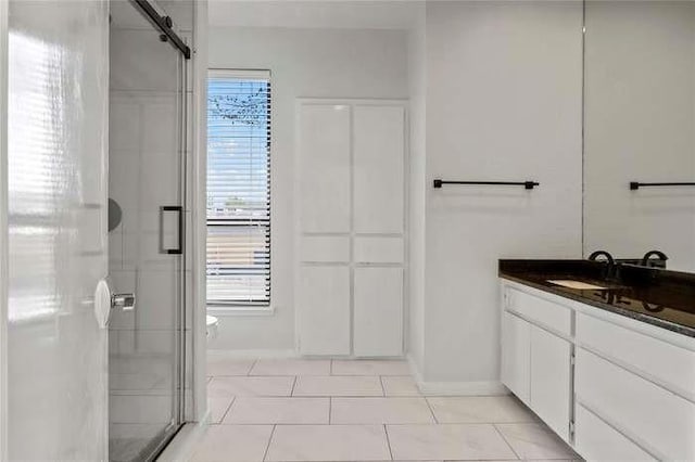 bathroom with an enclosed shower, tile patterned floors, and vanity