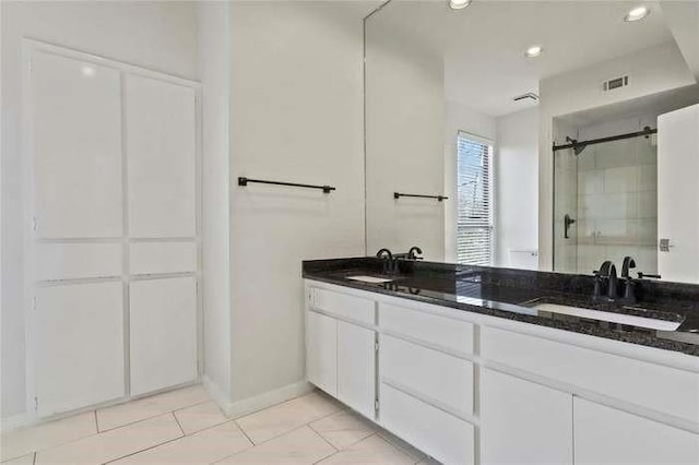 bathroom with walk in shower, tile patterned floors, and vanity