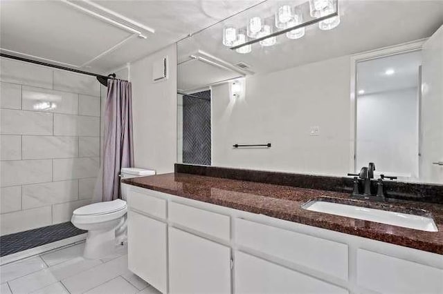 bathroom featuring toilet, vanity, tile patterned floors, and walk in shower