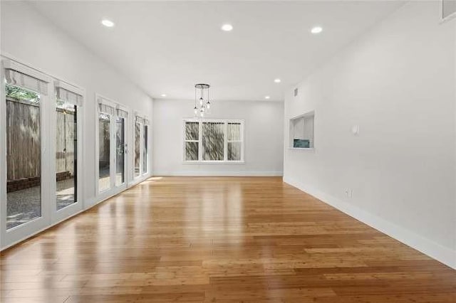 interior space with an inviting chandelier and light hardwood / wood-style floors