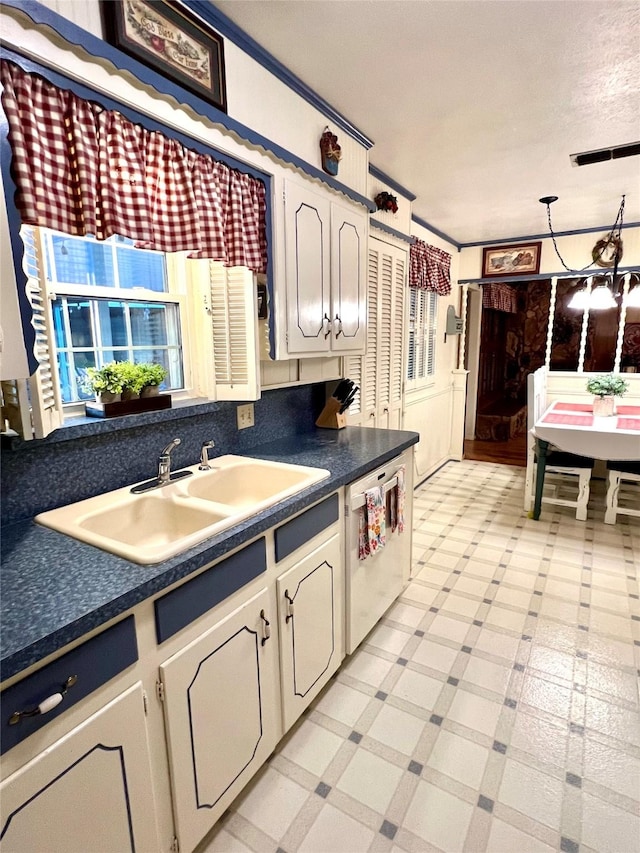 kitchen featuring white cabinetry, a textured ceiling, dishwasher, and sink