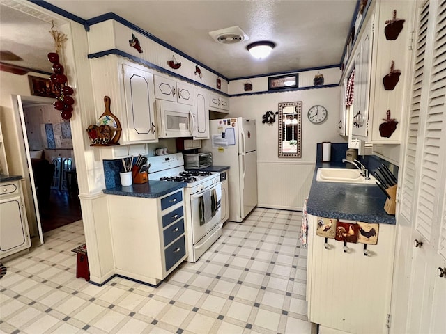 kitchen featuring sink, white appliances, and white cabinets